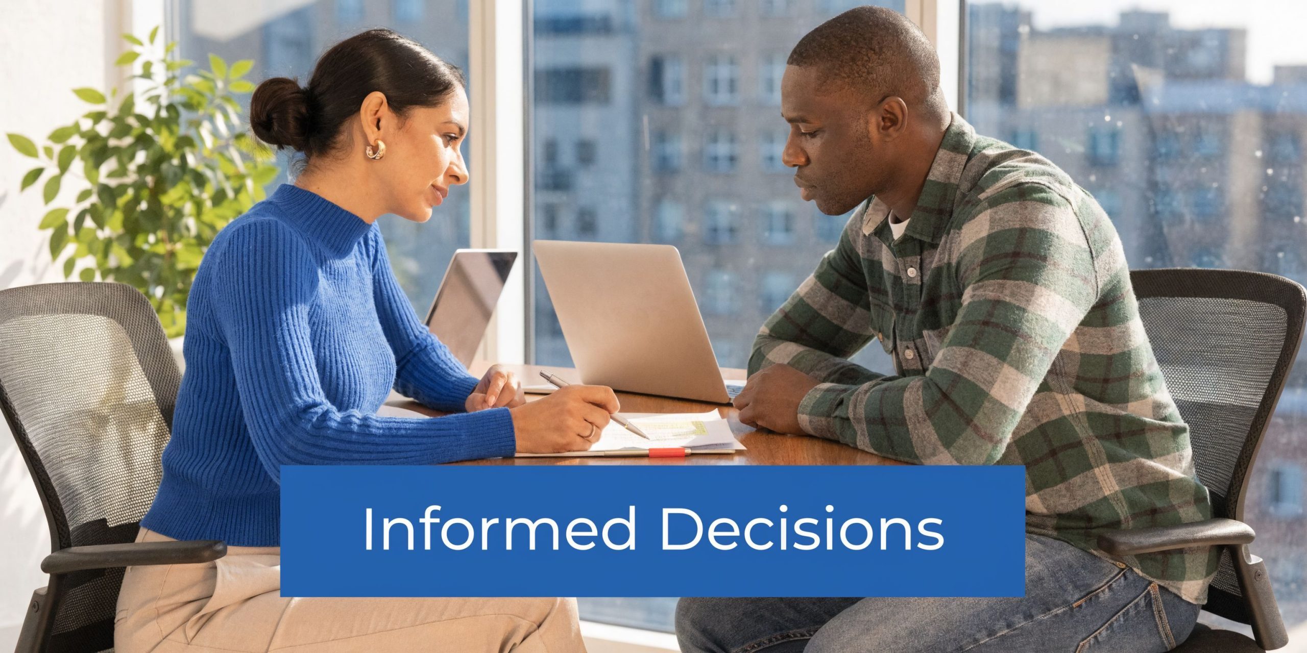 A professional woman and man having a business meeting while reviewing documents at an office table.