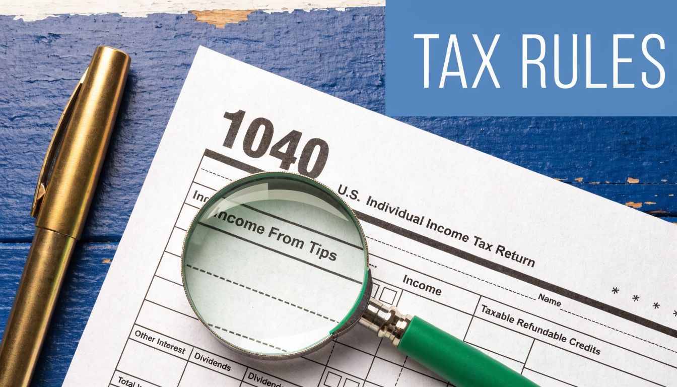 A magnifying glass resting on a 1040 tax return form next to a gold pen