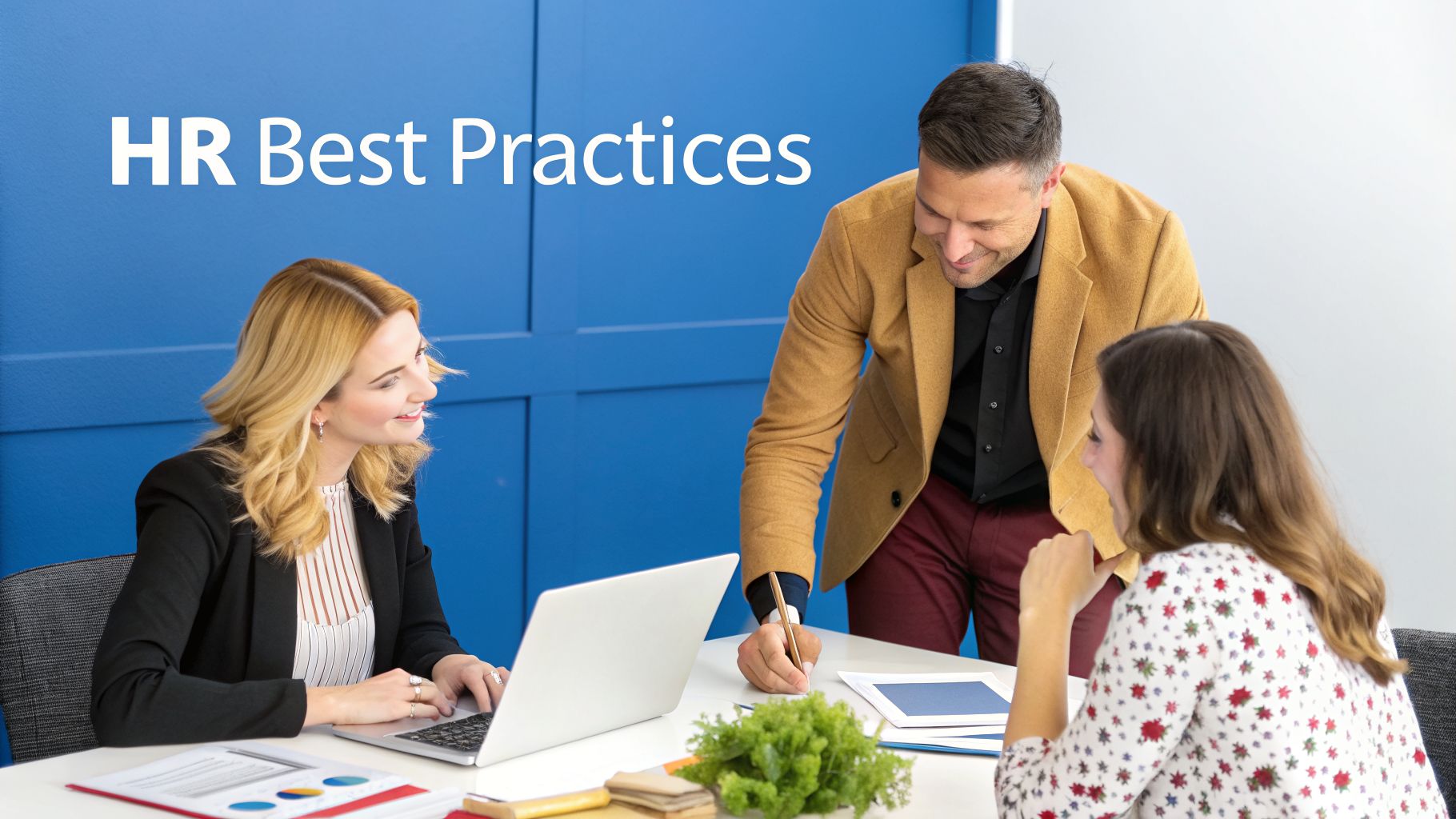 Three professionals collaborating on HR best practices in a modern office setting with a laptop and documents.